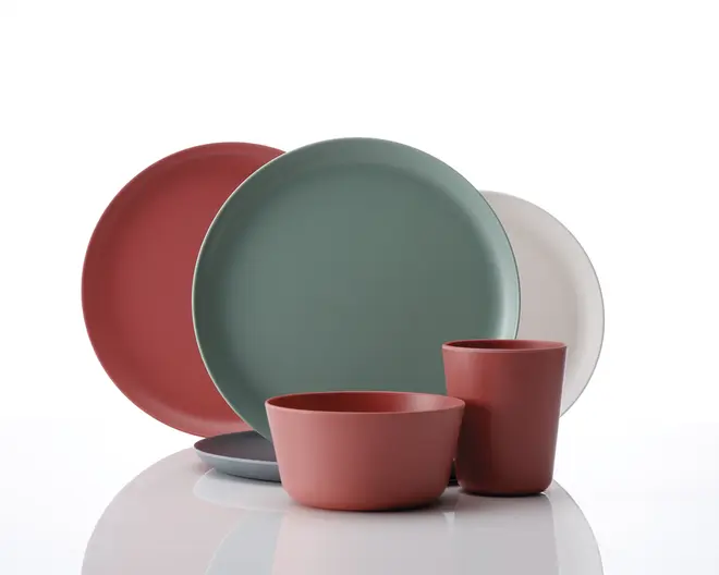 Et sæt moderne service med mat finish i afdæmpede farver som terrakotta, salviegrøn, grå og offwhite. Sættet består af store, runde tallerkener, en skål og et krus, alle med glatte, rene linjer og et minimalistisk design. Overfladerne er uden dekoration, hvilket fremhæver de ensfarvede nuancer og det moderne udtryk.