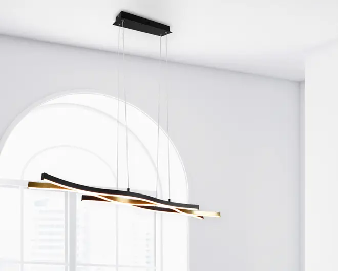 Moderne pendellampe med to sammenflettede, bølgeformede stænger ophængt fra loftet i fire tynde, justerbare kabler. Stængerne har en elegant sort og gylden finish med integreret LED-belysning, der udsender et varmt, diffust lys. Det minimalistiske design og de bløde kurver gør lampen velegnet til moderne indretning, hvor den både fungerer som belysning og dekorativt element.