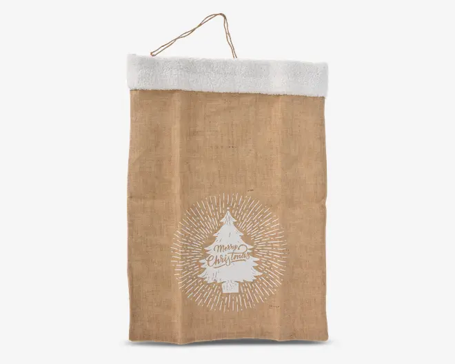 Stor sæk i jute-look med hvidt kunstpelskant øverst og et rebhåndtag til ophængning. Forsiden har et hvidt juletræsmotiv med teksten 'Merry Christmas' i midten, omgivet af strålende linjer. Materialet har en rustik, naturlig struktur, som giver et hyggeligt og julet udtryk.
