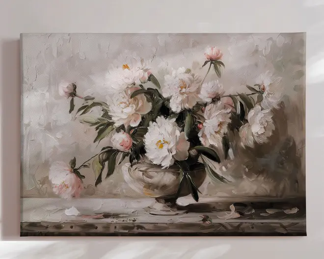 Et lærredsmaleri med en buket hvide og lyserøde pæoner arrangeret i en klassisk fodet vase. Blomsterne er malet med bløde, teksturerede penselstrøg, hvilket giver dybde og realisme. Baggrunden er i neutrale, afdæmpede nuancer, som får de sarte kronblade og grønne blade til at træde frem. Enkelte blade og kronblade ligger spredt på overfladen under vasen, hvilket giver et naturligt og afslappet udtryk til kompositionen.
