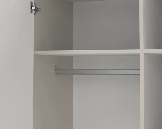 Indvendigt billede af et garderobeskab med en bøjlestang til tøj, en rummelig hylde over stangen samt ekstra lodrette og vandrette opdelinger for organiseret opbevaring. Skabet har en glat, lys overflade, og der ses et metalhængsel på den åbne dør.