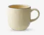 Et keramikkrus med en glat, blank overflade i en blød cremefarve. Kruset har en rundet form, et behageligt buet håndtag og en diskret mørk kant langs toppen. Indersiden er også cremefarvet og matcher ydersiden. Designet er enkelt og moderne, velegnet til daglig brug.