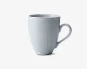 Hvid keramikkop med en glat, blank overflade. Koppen har en let udadbuet kant og et behageligt, buet håndtag. Øverst på koppen løber et diskret, hævet linjemønster hele vejen rundt, hvilket giver et elegant og stilrent udtryk.