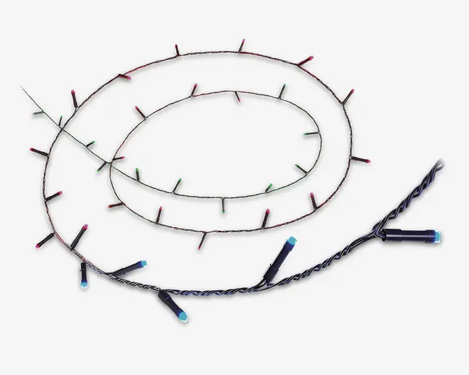 En sammenrullet lyskæde med små LED-lys på en tynd, mørk snoet ledning. Lysene er jævnt fordelt langs ledningen og lyser i forskellige farver, herunder rød, grøn og blå. Pærerne er cylindriske og kompakte, hvilket gør kæden velegnet til dekoration i forskellige omgivelser.