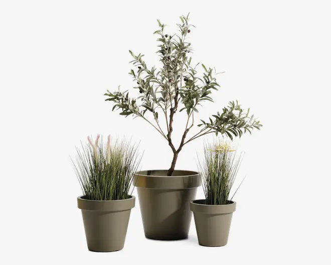 Sæt med tre kunstige planter i matte taupefarvede plastikpotter. Den midterste plante er et lille træ med slanke grene og tætte, brogede grønne blade. De to sideplanter har høje, tynde græsagtige blade med hvide spidser, hvilket giver et blødt, naturligt udtryk. Alle potter har et enkelt, moderne design med let udadbuet kant.