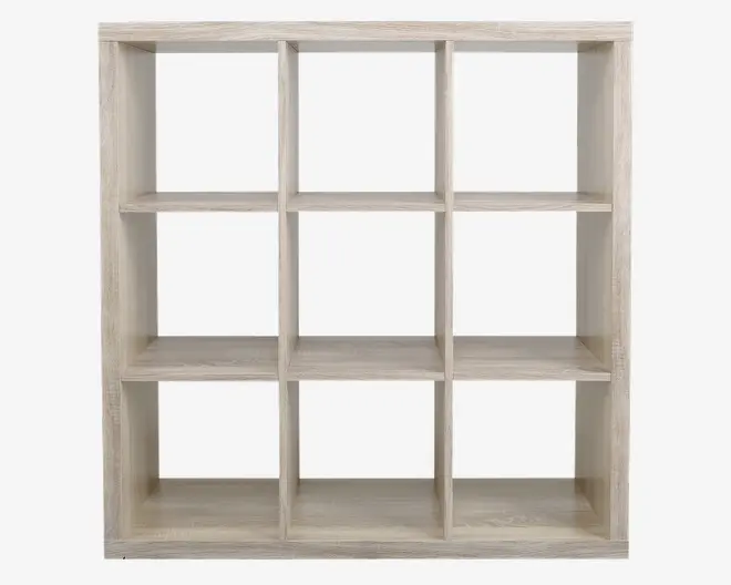 En reol med lys træfinish og et rektangulært stel, der har ni lige store kvadratiske rum arrangeret i et 3x3 gitter. Hylderne har en glat overflade og rene, lige kanter, hvilket giver et moderne og minimalistisk udtryk. Den åbne bagside gør det muligt at placere reolen fleksibelt og giver nem adgang til indholdet fra begge sider.