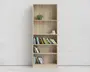 Høj, rektangulær reol i lyst træ med fem hylder. Øverste hylde har en lille potteplante, anden hylde har en lille sølvfarvet skål og tallerken, og de resterende hylder viser forskellige bøger, der står oprejst og skråt. Designet er minimalistisk og moderne med en naturlig træstruktur.