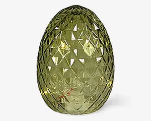 Æggeformet dekorationsgenstand lavet af gennemsigtigt grønt glas med en facetslebet, diamantmønstret overflade, der reflekterer lyset. Overfladens tekstur giver en glitrende effekt, og genstanden fremstår glat og blank.