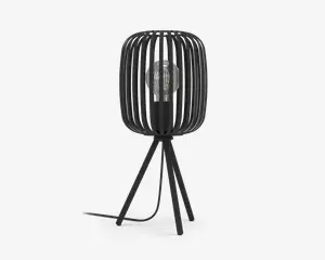 Moderne bordlampe med sort metalskærm i et bur-design, hvor lodrette stænger omkranser en synlig pære. Lampen står på tre skråtstillede ben og har en sort ledning, der går ud fra bunden. Designet er minimalistisk og industrielt, og pæren er i centrum af udtrykket.