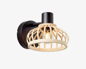 Væghængt lampe med rund sort metalbase og arm, samt en dekorativ åben lampeskærm af lyse trælameller. Skærmen omslutter en synlig pære, hvilket giver god lysfordeling og et moderne, naturligt udtryk.