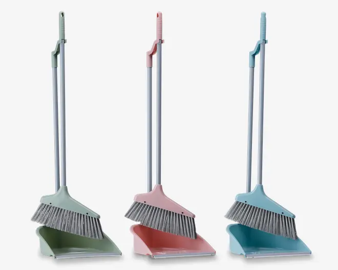 Tre sæt rengøringsredskaber, hver bestående af en kost og en fejebakke med lange metalhåndtag. Sættene er i pastelfarver: grøn, lyserød og blå. Hver fejebakke har en flad kant for nem fejning og en indbygget kamfunktion til at rense kostens børster. Kostens håndtag kan klikkes fast på fejebakkens håndtag for kompakt opbevaring.