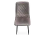 Stol med blødt, velourlignende betræk i en afdæmpet grå farve. Sædet og ryglænet har et quiltet design med diamantmønster, som giver ekstra struktur og stil. Stolen har en let buet ryg og sæde for komfort og står på slanke, sorte metalben.