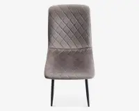 Stol med blødt, velourlignende betræk i en afdæmpet grå farve. Sædet og ryglænet har et quiltet design med diamantmønster, som giver ekstra struktur og stil. Stolen har en let buet ryg og sæde for komfort og står på slanke, sorte metalben.