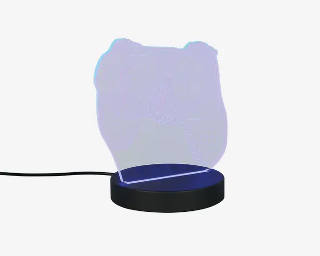 En dekorativ LED-lampe med en klar akrylplade, der har et indgraveret omrids af en videospil-controller. Pladen oplyses fra basen, som udsender et blødt blåt skær. Lampen får strøm via et USB-kabel, der er tilsluttet siden af den runde sorte base. Designet er moderne og minimalistisk, hvilket gør den velegnet til gamer-værelser eller som natlampe.