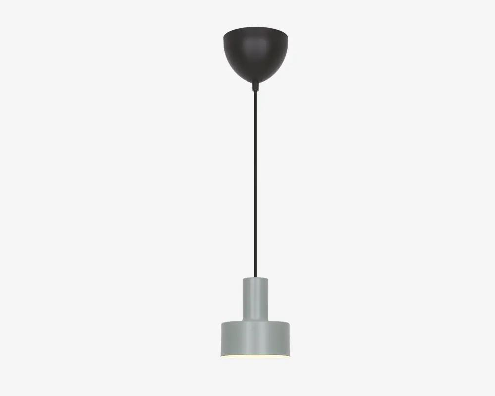 En moderne pendellampe med en cylindrisk skærm i mat grå, der har en let forhøjet topsektion. Lampen hænger fra en sort ledning, som er fastgjort til en rund, sort loftroset. Designet er minimalistisk og nutidigt, velegnet til forskellige indretninger.