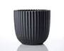 En mat sort beholder med lodrette riller og bølget kant. Formen er cylindrisk med en let afrundet bund, og overfladen har et moderne, minimalistisk udtryk.