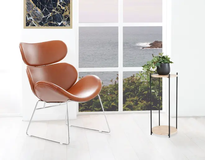 En moderne stol med skulptureret, buet sæde og ryglæn betrukket med glat brunt læder. Stolen har en slank, minimalistisk ramme i krommetal med slædeben. Sædet og ryglænet er godt polstrede for komfort, og det samlede design er moderne og stilfuldt, velegnet til stue eller kontor.