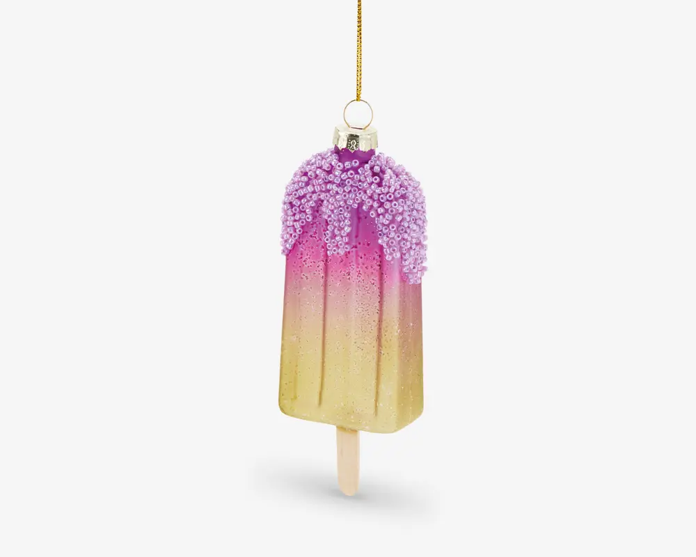 En dekorativ ornament formet som en ispind, med en farvegradient fra gul i bunden til pink i toppen. Den øverste del er dækket af lilla, teksturerede krymmel, og der er en gylden ophængssnor fastgjort i toppen til ophængning.