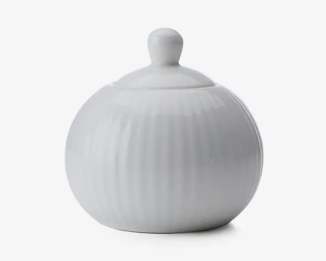 Rund, hvid keramisk beholder med tilhørende låg, der har et knopformet håndtag. Overfladen har diskrete lodrette riller, som giver tekstur, og det samlede design er glat og blankt.