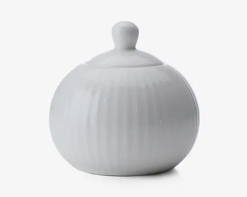 Rund, hvid keramisk beholder med tilhørende låg, der har et knopformet håndtag. Overfladen har diskrete lodrette riller, som giver tekstur, og det samlede design er glat og blankt.