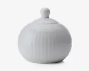 Rund, hvid keramisk beholder med tilhørende låg, der har et knopformet håndtag. Overfladen har diskrete lodrette riller, som giver tekstur, og det samlede design er glat og blankt.