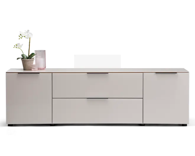 Et moderne, lavt opbevaringsmøbel med mat lysegrå finish. Det har to store centrale skuffer med slanke, vandrette greb, flankeret af to skabslåger på hver side, hver med matchende greb. Topfladen er flad og rummelig, velegnet til dekoration; på billedet står en potteorkidé og en rillet glasvase. Designet er minimalistisk med rene linjer og uden synlig udsmykning.