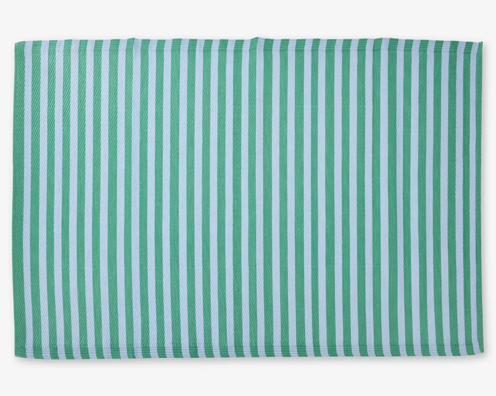 Rektangulært stof med et mønster af jævnt fordelte lodrette striber i skiftevis grøn og hvid. Materialet ser ud til at have en tekstureret vævning, og kanterne er pænt afsluttede.