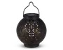 Rund sort lanterne med indviklede udskæringer i overfladen, som lader et varmt gult lys skinne igennem. Lanternen har et håndtag øverst til ophængning og et solcellepanel integreret i låget til opladning. Designet skaber dekorative lysmønstre, når den er tændt.