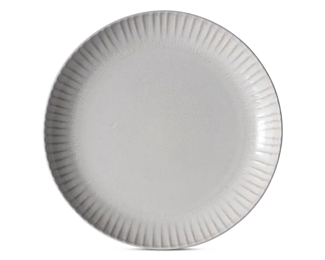 Rund hvid tallerken med riflet kant og glat midterflade, vist ovenfra på en ensfarvet baggrund.