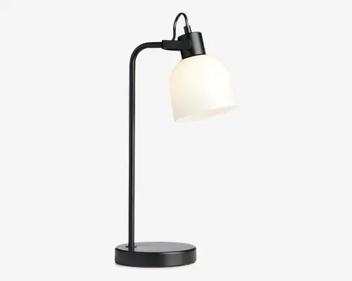 Moderne skrivebordslampe med mat sort metalstel, rund base og buet arm. Lampen har en stor, kuppelformet hvid glasskærm, der giver blødt, diffust lys. Skærmen er fastgjort til armen med et synligt hængsel, så vinklen kan justeres. Designet er stilrent og minimalistisk, velegnet til moderne indretning.