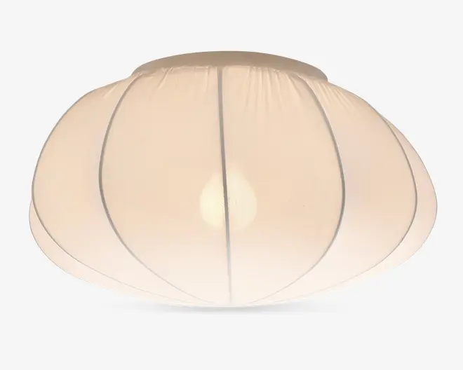 En kuppelformet lampeskærm lavet af gennemsigtigt hvidt stof med lodrette syninger, der giver et blødt segmenteret udtryk. Materialet spreder lyset jævnt og skaber en varm og hyggelig belysning. Designet er minimalistisk og moderne, velegnet til forskellige indretninger.
