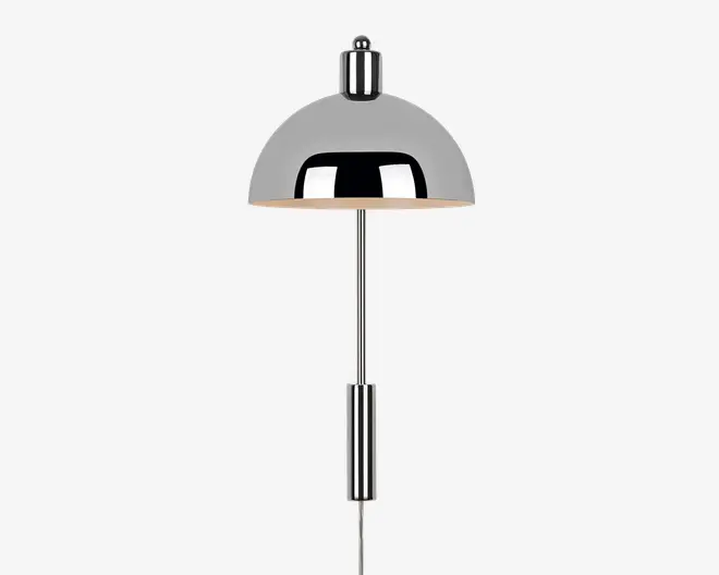 En moderne lampe med blank kromfinish, der har en kuppelformet skærm og en slank, lige stang. Lampen har et minimalistisk design med rene linjer, og den reflekterende overflade giver et stilrent, moderne udtryk. Skærmen leder lyset nedad, hvilket gør den velegnet til fokuseret belysning.