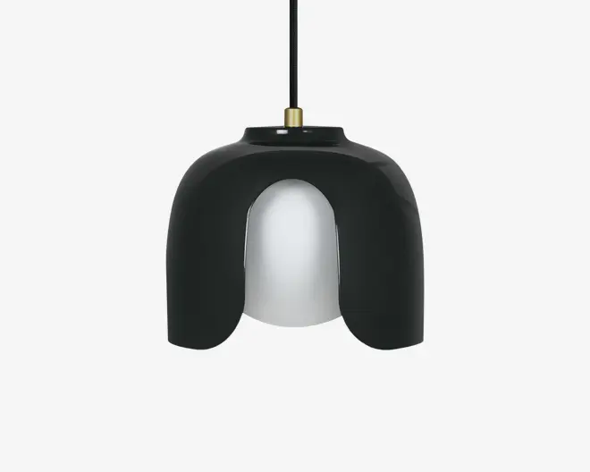 Loftlampe med et moderne, skulpturelt design, der har en blank sort yderskærm, som buer nedad i tre sektioner og delvist afslører en mat hvid indre diffuser. Lampen hænger i en sort ledning med en messingdetalje øverst, hvilket giver et stilfuldt udtryk.
