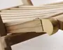 Nærbillede af en træstruktur med glatte, buede lameller og et poleret hjørnebeslag i messing. Træet har en naturlig, lys finish, og messingbeslaget giver et dekorativt og solidt præg på samlingen. Håndværket fremhæver rene linjer og præcis samling.