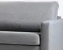 Nærbillede af en grå polstret sofa med fin vævet tekstur, tyk sædehynde, høj ryg og kantet armlæn.