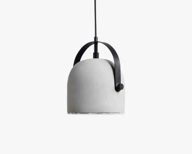 Loftlampe med en glat, kuppelformet skærm i mat lysegrå. Lampen har et karakteristisk sort metalhåndtag, der buer over toppen og er fastgjort med en synlig rund knop på den ene side. Designet er moderne og minimalistisk med en ren silhuet og en synlig ledning, der går ud fra toppen.