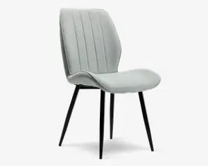 Stol med lysegråt polstret sæde og ryglæn, der har lodrette syninger for ekstra struktur. Sædet og ryglænet er let buede og ergonomisk formet for komfort. Stolen står på fire slanke, sorte metalben, der er let skråtstillede og giver et moderne og minimalistisk udtryk.