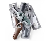 Et udvalg af langhalsede lightere i forskellige farver, herunder brun, mintgrøn, sort og hvid, hver enkelt pakket individuelt i gennemsigtige plastblisterpakker. Lighterne har ergonomisk greb, synligt brændstofvindue og en sikkerhedslås tæt på tændingsknappen.