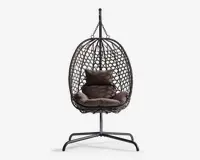 Hængende æggeformet stol med en flettet ramme i rattan-stil, understøttet af et robust metalstativ. Stolen har bløde, mørkebrune hynder til sidde- og rygstøtte samt en ekstra pude for øget komfort. Den åbne gitterstruktur giver god luftcirkulation og et moderne udseende.