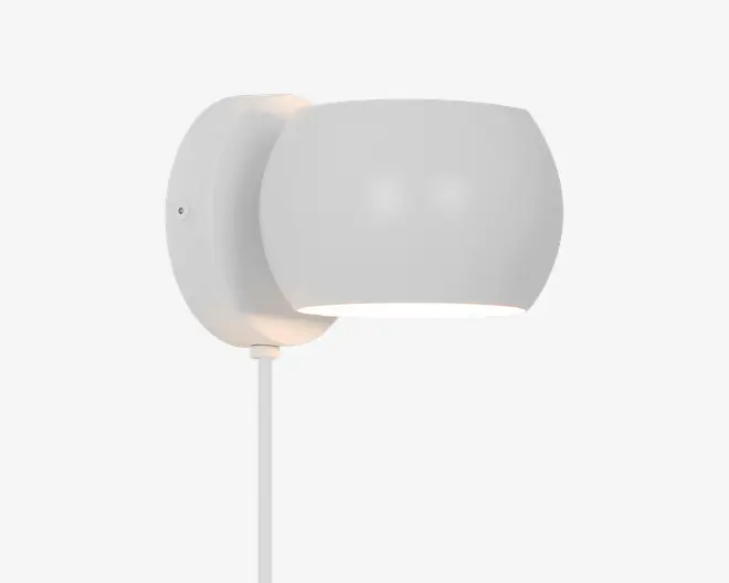 Moderne vægmonteret lampe med en glat, rund skærm i mat hvid og en cirkulær base. Designet er minimalistisk, lyset rettes nedad, og der er en synlig ledning, der går ud fra bunden. Lampen har et rent og nutidigt udtryk, der passer til mange indretninger.