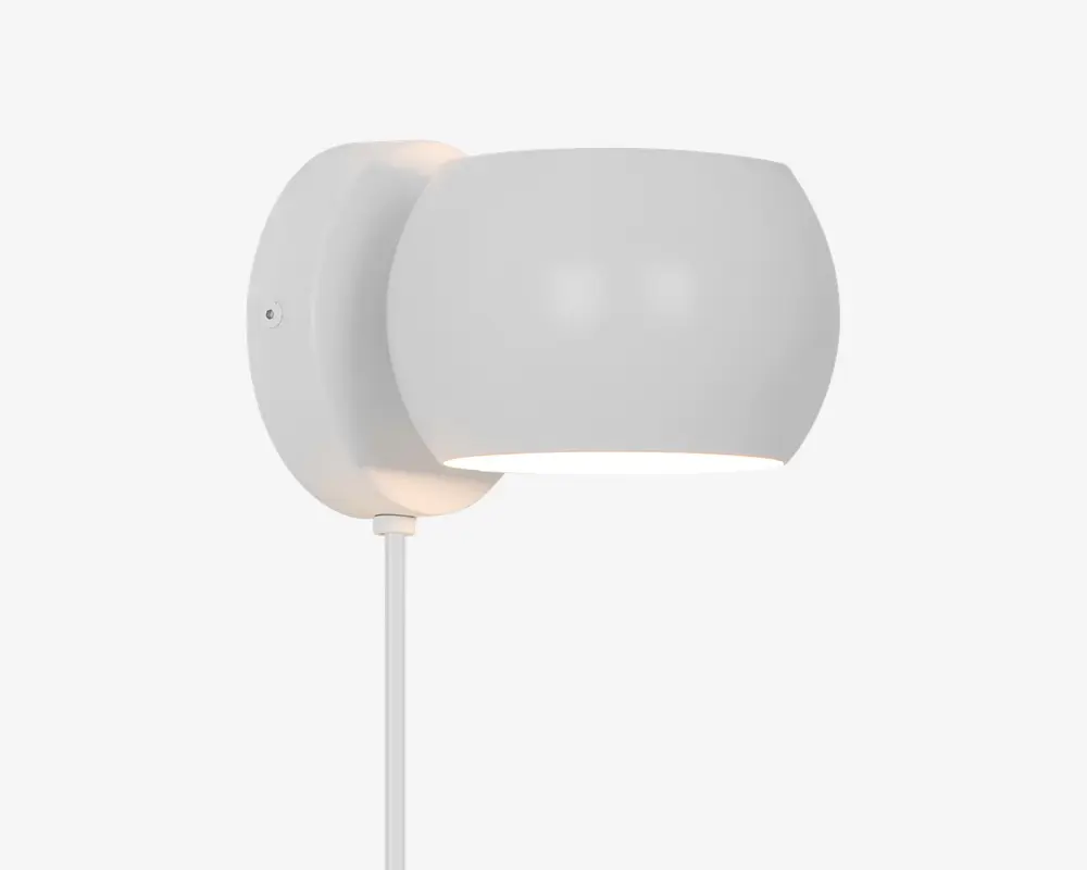 Moderne vægmonteret lampe med en glat, rund skærm i mat hvid og en cirkulær base. Designet er minimalistisk, lyset rettes nedad, og der er en synlig ledning, der går ud fra bunden. Lampen har et rent og nutidigt udtryk, der passer til mange indretninger.