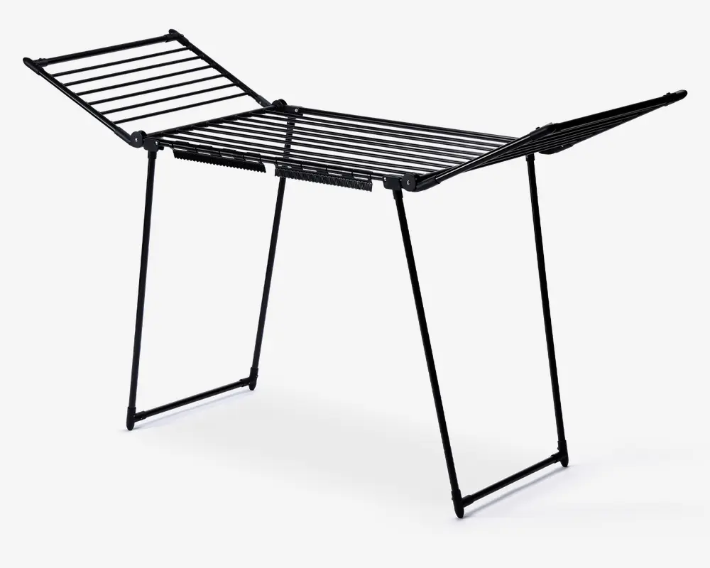 Sammenklappeligt tørrestativ med sort metalstel, bestående af en central rektangulær sektion og to sidefløje, der kan foldes ud for ekstra hængeplads. Stativet står på fire stabile ben og har flere parallelle stænger til ophængning af tøj. Velegnet til brug både inde og ude, og kan nemt foldes sammen for opbevaring.