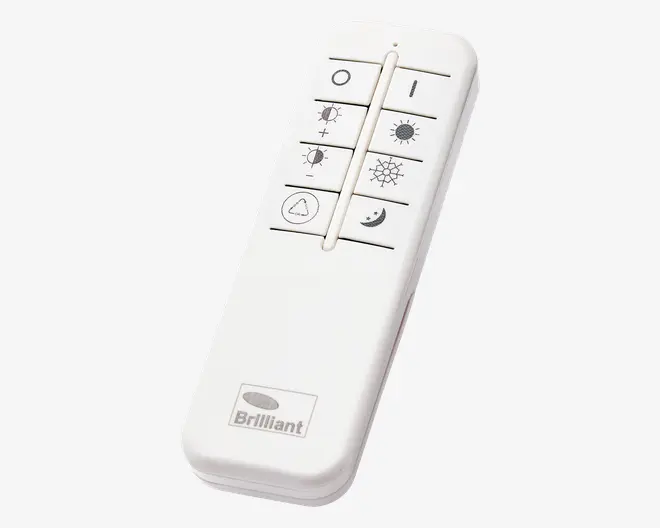 Hvid fjernbetjening med otte rektangulære knapper arrangeret i to kolonner. Knapperne har ikoner for tænd/sluk, øg og sænk lysstyrke, lys tændt, lys slukket, timer og nattilstand. Nederst ses 'Brilliant'-logoet.