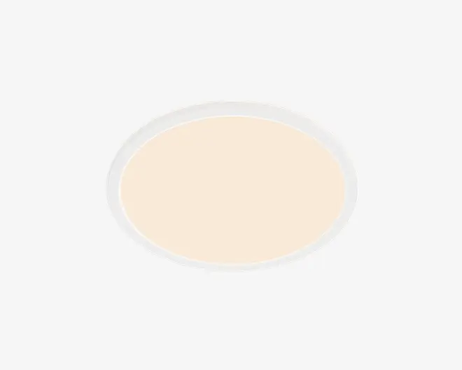Oval armatur med hvid yderrand og en glat varm beige midte, vist på sort baggrund.