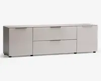 Et moderne, lavt opbevaringsmøbel med mat lysegrå finish. Det har to store skuffer i midten, hver med elegante vandrette metalhåndtag, samt to skabslåger på hver side med tilsvarende håndtag. Designet er minimalistisk med rene linjer og en glat overflade, velegnet til moderne indretning.