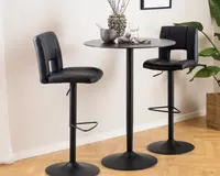 Sæt med to moderne barstole med sort kunstlæderpolstring, der har polstrede sæder og ryglæn for komfort. Hver stol har en robust sort metalbase med cirkulær fodstøtte og rund sokkel for stabilitet. Sæderne er let buede og har et åbent design nederst på ryggen. Stolene er kombineret med et rundt barbord i sort metal med slank sokkel. Udseendet er stilrent og moderne, velegnet til køkken eller barområde.