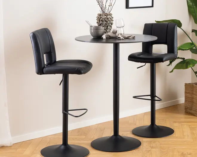 Sæt med to moderne barstole med sort kunstlæderpolstring, der har polstrede sæder og ryglæn for komfort. Hver stol har en robust sort metalbase med cirkulær fodstøtte og rund sokkel for stabilitet. Sæderne er let buede og har et åbent design nederst på ryggen. Stolene er kombineret med et rundt barbord i sort metal med slank sokkel. Udseendet er stilrent og moderne, velegnet til køkken eller barområde.