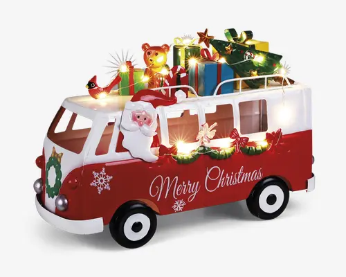 En festlig rød og hvid varevogn dekoreret med juletema. Varevognen har teksten 'Merry Christmas' på siden, snefnugmotiver og en grøn krans foran. En tredimensionel julemandsfigur sidder i førervinduet. På taget er der stablet farverige indpakkede gaver, en bamse, et juletræ og en gul stjerne. Hele dekorationen er oplyst af små, varme hvide LED-lys, som giver et hyggeligt og festligt udtryk.