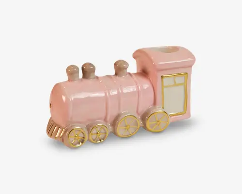 Dekorativt tog i keramik, formet som et damplokomotiv i pastelpink med guldfarvede detaljer. Har fire hjul med guldfarvede eger, tre forhøjede kupler på toppen og et rektangulært førerhus med hvidt og guldfarvet vinduesmotiv. Overfladen er blank, og designet er glat og afrundet, hvilket giver et legende og charmerende udtryk.