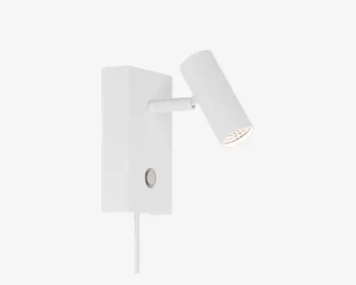 Moderne vægmonteret spotlampe med mat hvid finish. Lampen har et cylindrisk, justerbart hoved til retningsbestemt belysning, monteret på en rektangulær base. Der er en rund trykknap på fronten og en synlig ledning, der går ud fra bunden. Minimalistisk design, der passer til moderne indretning.